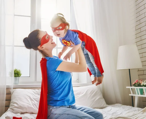 Mädchen und Mutter im Superheldenkostüm — Stockfoto