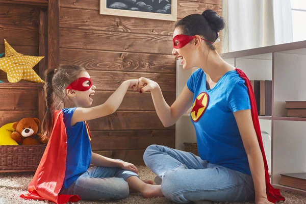 Meisje en moeder in een superheld kostuum — Stockfoto