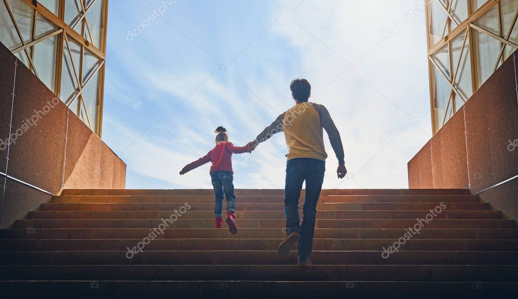 Father and child climb upstairs.