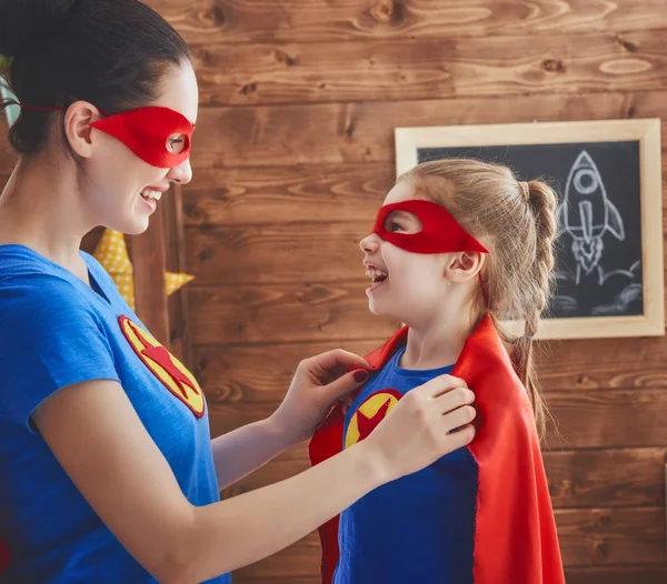 Meisje en moeder in superheld kostuums — Stockfoto