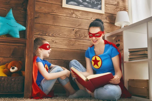 Mädchen und Mutter im Superheldenkostüm — Stockfoto