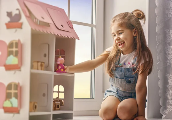 Girl plays with doll house — Stock Photo, Image