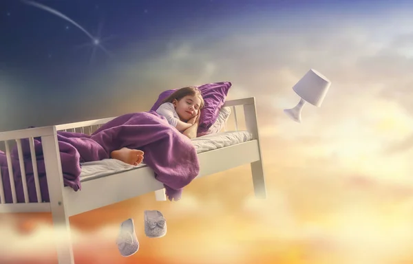Menina está voando em sua cama — Fotografia de Stock