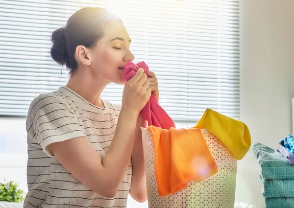 Mulher está cheirando roupas limpas — Fotografia de Stock
