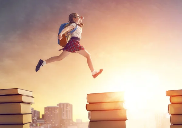 Child running and jumping on books — Stock Photo, Image