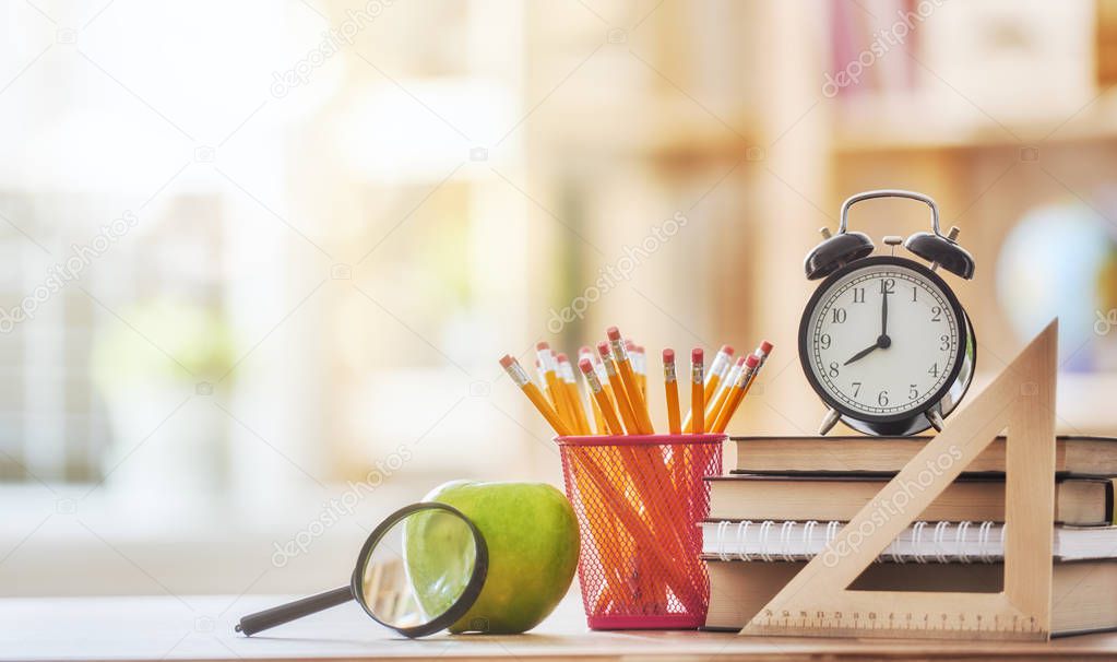 Apple, pile of books and pencils