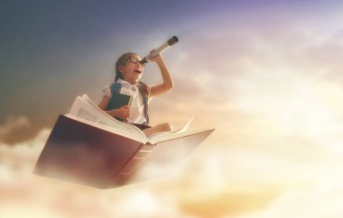 belgili tanımlık kitap üstünde uçan çocuk