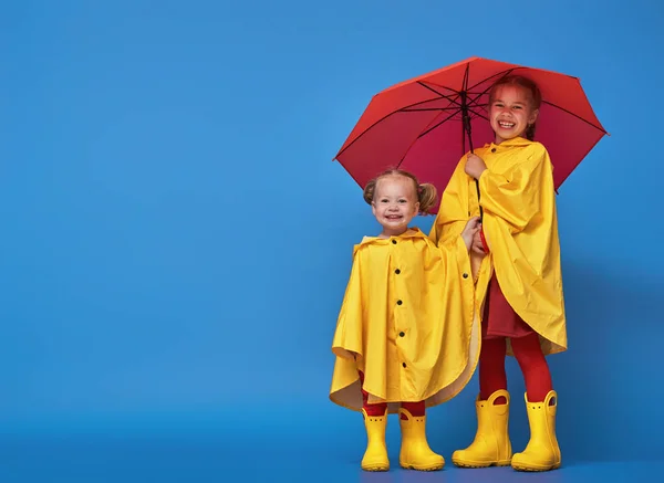 Дети с красным зонтиком — стоковое фото