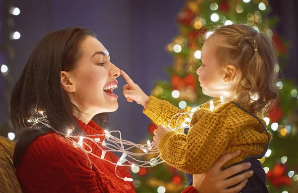 Moeder en dochter bij de kerstboom — Stockfoto