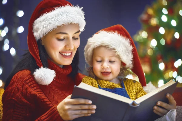 Mãe lendo um livro no Natal — Fotografia de Stock