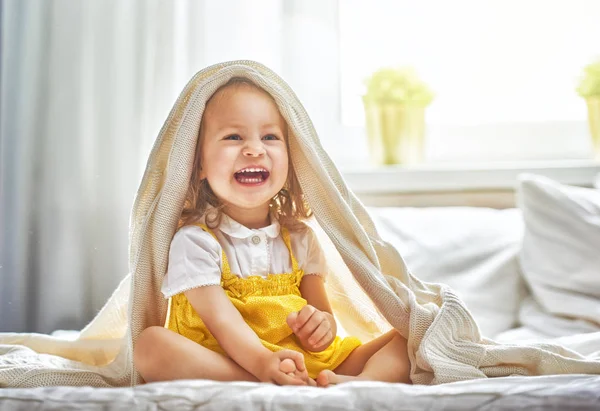 Meisje van de baby op het bed — Stockfoto