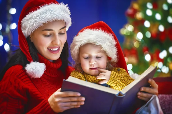 Mãe lendo um livro no Natal — Fotografia de Stock