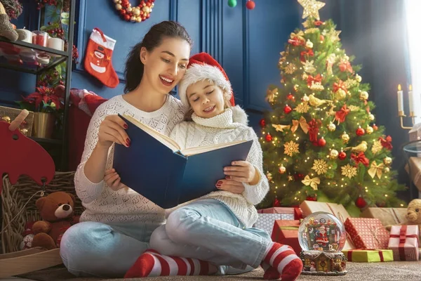 Mutter liest zu Weihnachten ein Buch — Stockfoto