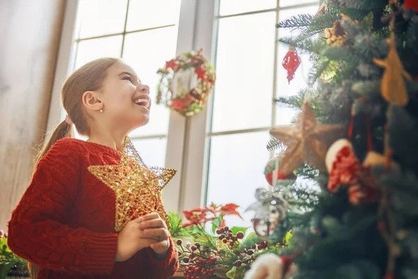 Menina está decorando árvore de Natal — Fotografia de Stock