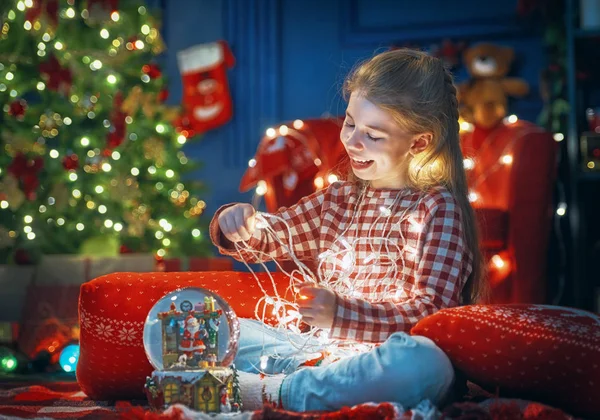 Kid in de buurt van de kerstboom. — Stockfoto