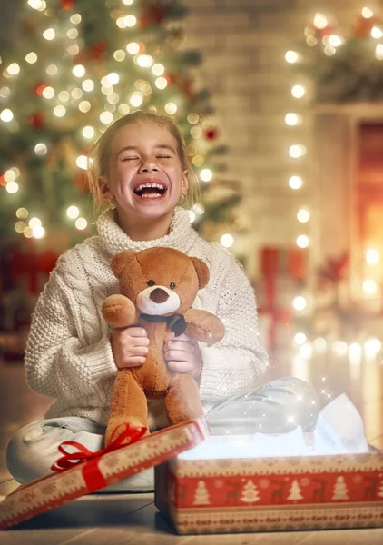 Chica con regalo cerca del árbol de Navidad — Foto de Stock