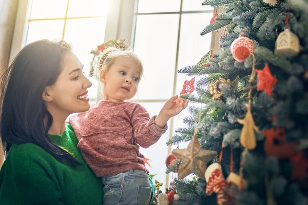 Mom and daughter decorate Christmas tree