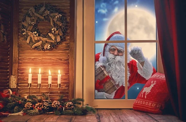 Weihnachtsmann klopft an Fenster — Stockfoto