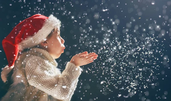 Chica soplando en la nieve — Foto de Stock