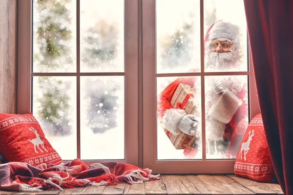 Santa Claus puka w okno — Zdjęcie stockowe