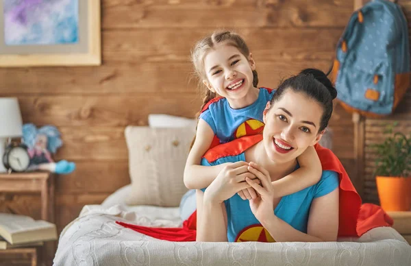 Mädchen und Mutter im Superheldenkostüm — Stockfoto