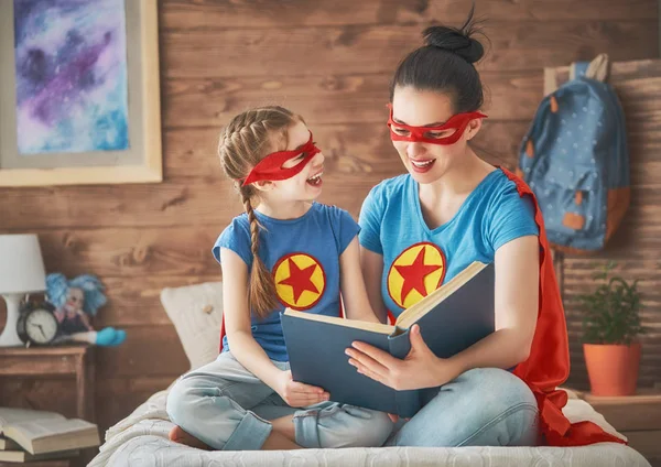 Tjej och mamma i superhjälte kostym — Stockfoto