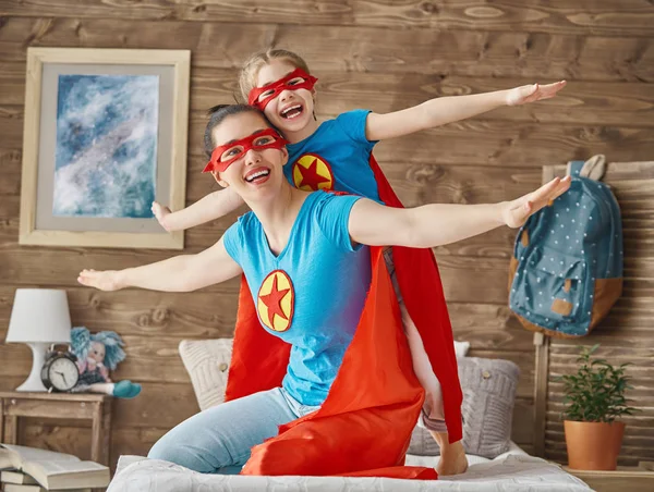 Mädchen und Mutter im Superheldenkostüm — Stockfoto