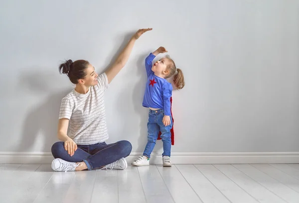 Mother is measuring growth of child — Stock Photo, Image