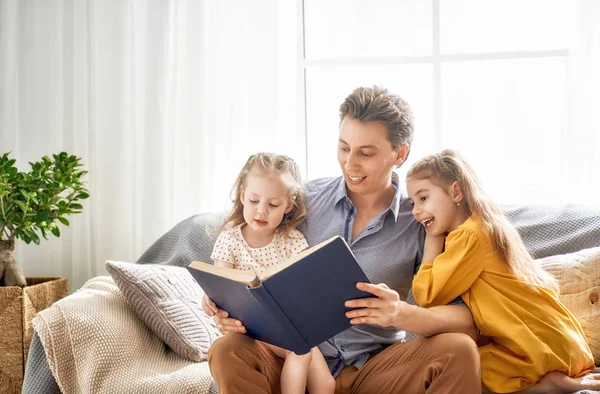 Pai lendo um livro para suas filhas — Fotografia de Stock