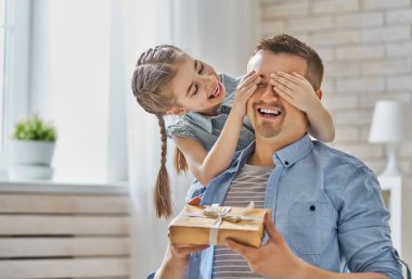 Mutlu Babalar günü! Baba tebrik ediyor ve giving onu hediye kutusu çocuk kızı. Baba ve kız gülümseyerek ve sarılma. Aile tatili ve beraberlik.