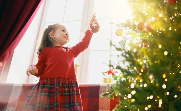 Niño con bolas cerca del árbol en casa . — Foto de Stock