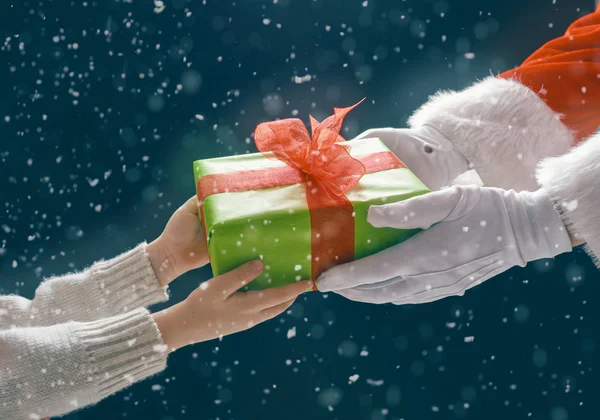 Santa claus dając prezent dla dziecka — Zdjęcie stockowe