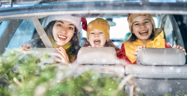 Moeder, kinderen en auto op besneeuwde winternatuur — Stockfoto