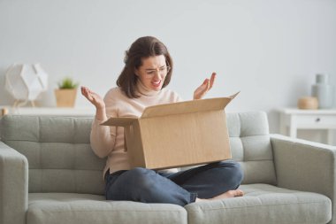 Kadın elinde karton kutu tutuyor.
