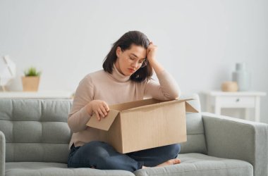 Kadın elinde karton kutu tutuyor.