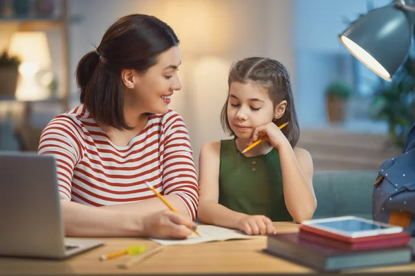 Mädchen macht Hausaufgaben mit Mutter — Stockfoto
