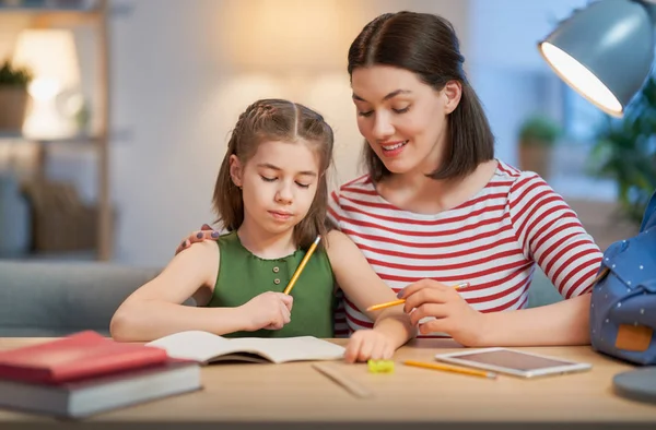 Meisje doet huiswerk met moeder — Stockfoto