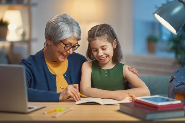 Chica estudiando con la abuela . —  Fotos de Stock