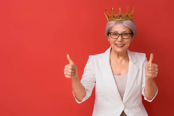 Seniorin posiert auf rotem Hintergrund — Stockfoto