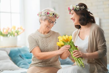 Güzel genç bir kadın ve elinde çiçeklerle annesi ellerinde laleler..  