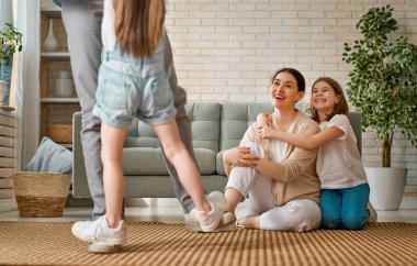 Mutlu aile! Anne ve babadan iki kız çocuğu. Annem, babam ve kızlar gülüyor ve sarılıyorlar..                                                               