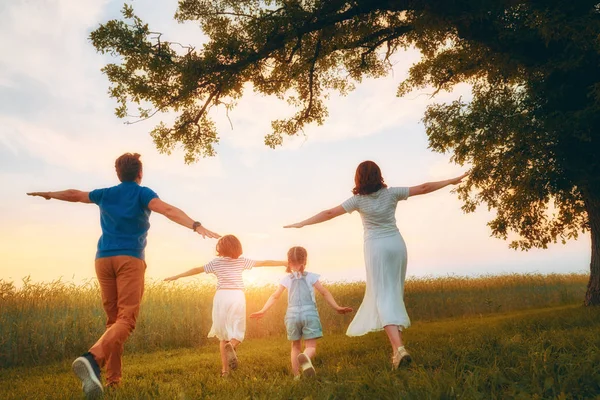 가족의 어머니와 아버지와 딸들은 공원을 거닐며 아름다운 자연을 즐긴다 — 스톡 사진