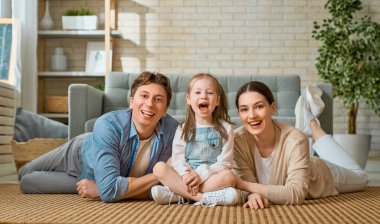 Mutlu aile! Annesi ve babası olan bir kız çocuğu. Anne, baba ve kız gülüyor ve sarılıyorlar.. 