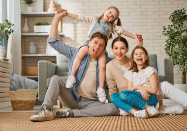 Mutlu aile! Anne ve babadan iki kız çocuğu. Annem, babam ve kızlar gülüyor ve sarılıyorlar.. 