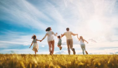 Yaz yürüyüşündeki mutlu aile! Anne, baba ve kızlar parkta yürüyor ve güzel doğanın tadını çıkarıyorlar..                               