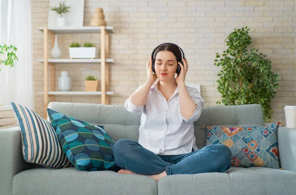 Fröhliche Junge Frau Hört Musik Über Kopfhörer Und Sitzt Hause — Stockfoto