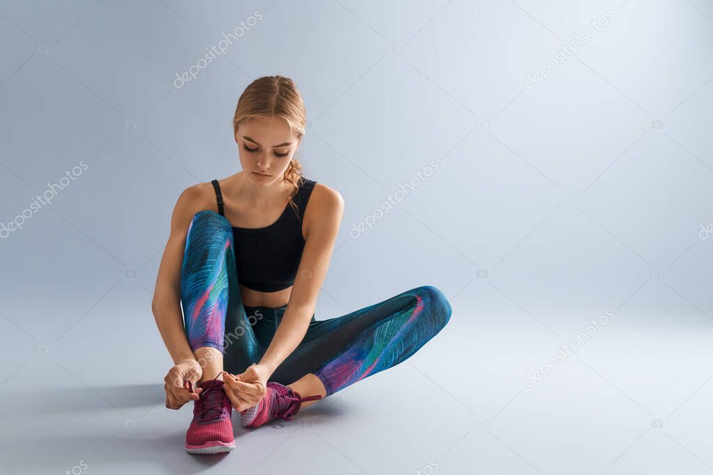 Healthy lifestyle and sport concepts. Woman in fashionable sportswear is doing exercise.                                