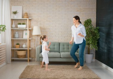 Anneler Günün kutlu olsun! Anne ve kızı oynuyorlar, gülümsüyorlar ve dans ediyorlar. Aile tatili ve birliktelik.                                