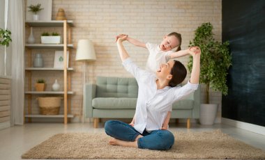 Anneler Günün kutlu olsun! Anne ve kızı oynuyorlar, gülümsüyorlar ve sarılıyorlar. Aile tatili ve birliktelik.