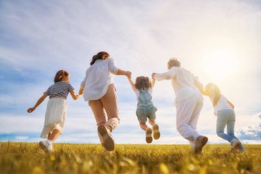 Yaz yürüyüşündeki mutlu aile! Anne, büyükanne ve kızları parkta yürüyor ve güzel doğanın tadını çıkarıyorlar..